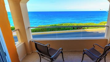 Ein Balkon mit zwei Stühlen und Blick auf den Ozean.