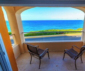 Un balcon avec deux chaises et une vue sur l’océan.