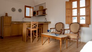A kitchen with wooden cabinets, a dining table, and two chairs.