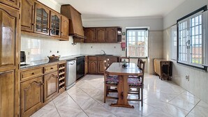 A kitchen with wooden cabinets, a dining table, and a window.
