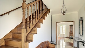 A wooden staircase with a wooden bench at the bottom.