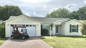 Uma casa térrea com garagem e entrada de automóveis.