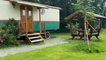 Step up to the charming porch of this cozy mobile home, featuring a glass-fronted entrance and a small window above.