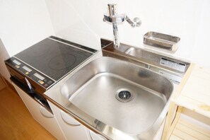 A compact kitchen with a stainless steel sink, a built-in stovetop, and a small dishwasher. - Sunny coast minamiboso ocean blue (Minamiboso)