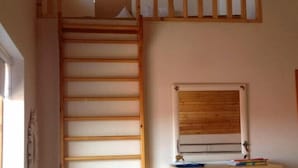 A room with a wooden ladder leading to a lofted sleeping area, a window, and a wooden dresser. - Great villa in the center of Reykjavik on the most beautiful valley of the town (Unknown)