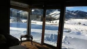 A room with a large window overlooking a snowy landscape with mountains. - Your Home In The Andes (San Martin de los Andes)