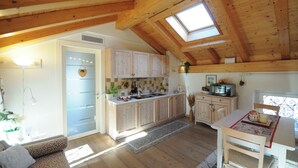 Une cuisine spacieuse dotée de meubles en bois, d’un îlot central et d’un coin repas avec une table et des chaises.