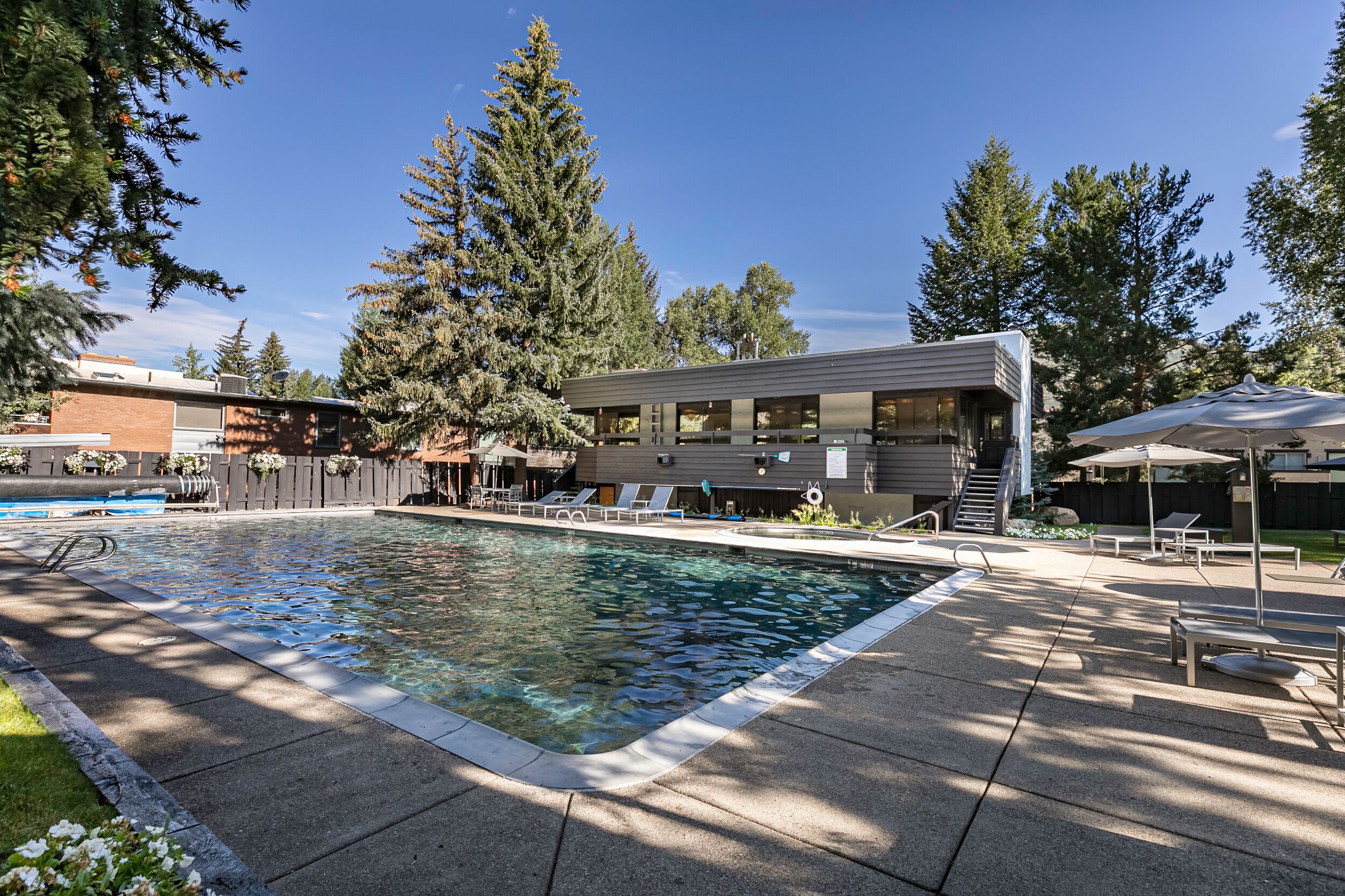 A swimming pool with lounge chairs and a covered patio area.