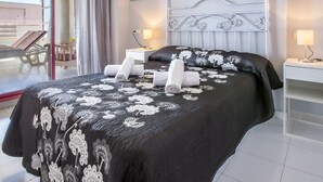 A hotel room with a bed, two bedside tables, a window with a view of the outside, and a balcony with chairs and a table. - FRONTLINE APARTMENT WITH BIG TERRACE AND BEATIFULL SEA VIEWS (Calpe)