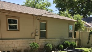 A house with a patio, a small garden, and a metal table with chairs. - Great Location!  Come Relax....Retreat!   (Kerrville)
