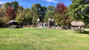 A park with a playground, picnic shelters, and a grassy field.
