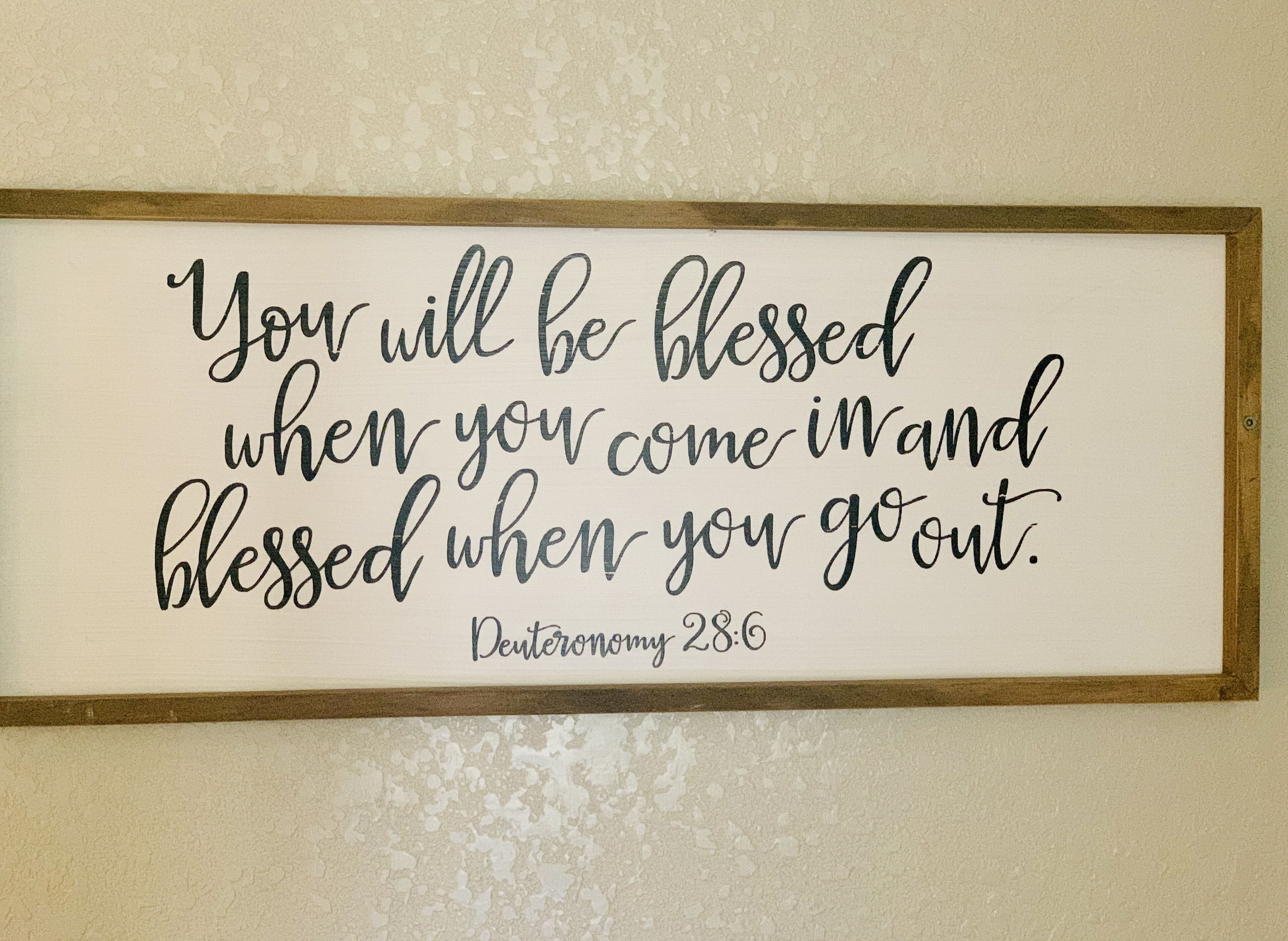 A framed inspirational quote on a textured wall.