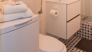 Une salle de bain avec des toilettes, un lavabo et une douche.
