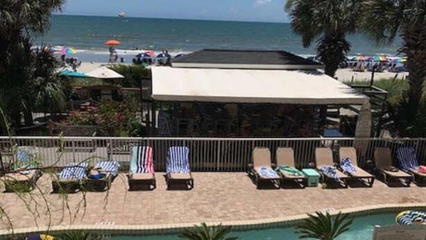 A pool area with lounge chairs and inflatable rafts. - Partial View 1 BR 1 BA, 8/28/26 to 9/4/26, Week 35, Fri-Fri, Room # 1302, (North Myrtle Beach)