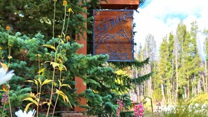 A garden with a sign that reads "SKI WATCH" surrounded by various plants and flowers. - Large Corner 2 Bedroom Unit Mountain Vibes (Breckenridge)