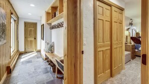 A hallway with wooden shelving, a bench, and a double wooden door. - Large Corner 2 Bedroom Unit Mountain Vibes (Breckenridge)