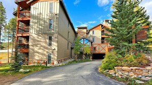 A multi-story building with balconies, a stone facade, and a clear sky. - Large Corner 2 Bedroom Unit Mountain Vibes (Breckenridge)