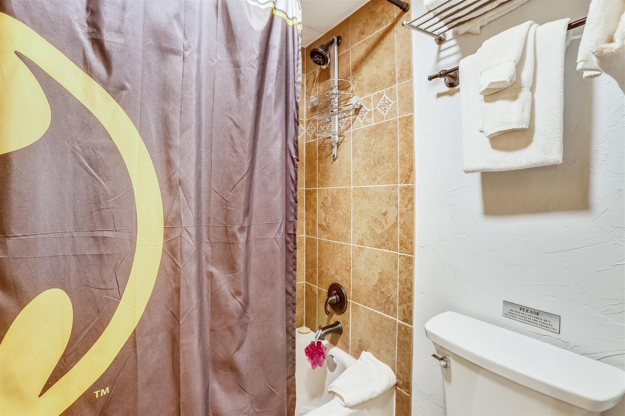 A bathroom with a shower, a toilet, and a towel rack.