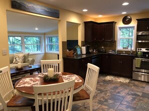 Enjoy meals in the kitchen with a dining area featuring a round table and comfortable seating.