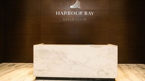 A reception desk with a marble top and a logo above it. - Lovina Residences at Harbour Bay (Batam)