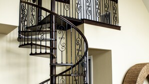 A spiral staircase with ornate black railings and wooden steps.