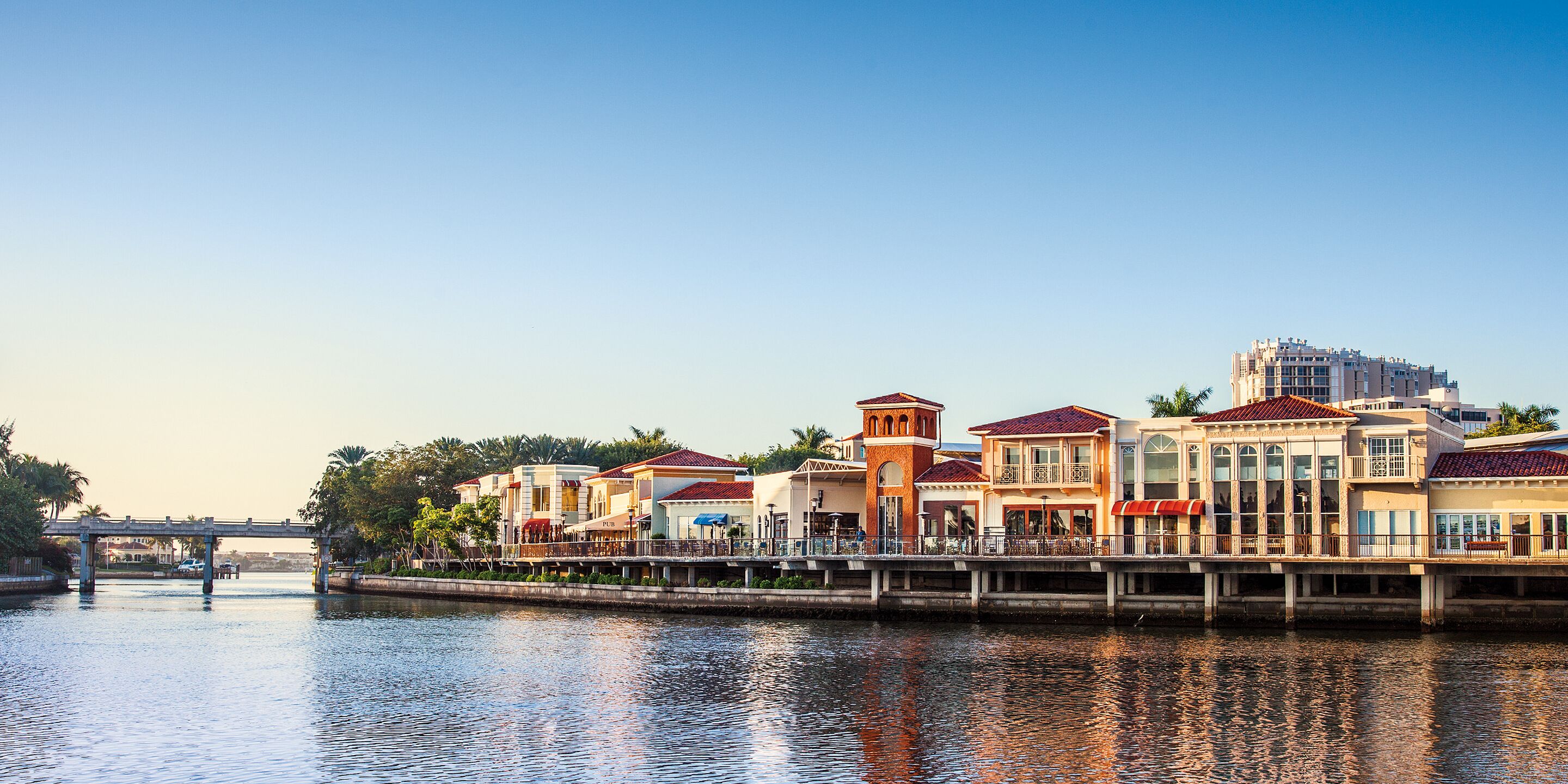 A waterfront hotel with multiple buildings, a bridge, and a canal.