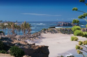 A beach with palm trees, a clear sky, and a view of the ocean. - Luxury 3 bedroom Punta Mita Residence villa (Bahia de Banderas)