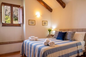 A bedroom with a bed, a window with open shutters, a bedside table with a vase, and two wall-mounted lights. - Terrace on the Infinite · Sea View · Amalfi Coast (Conca dei Marini)