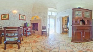 A spacious room with a stone fireplace, wooden furniture, and a large cabinet.