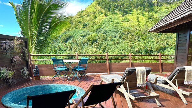 Une terrasse en bois avec une piscine, des chaises longues et une table avec des chaises.