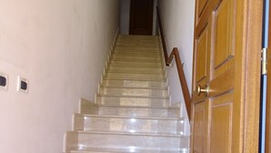 Eine Marmortreppe führt zu einer Tür mit einer Messingklinke.