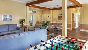 A lobby with a foosball table, sofas, and a coffee table.