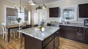 A kitchen with dark wood cabinets, a granite countertop, and a central island.