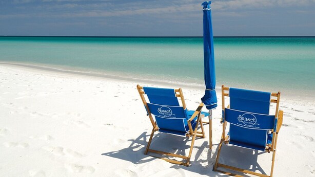 Two blue beach chairs with a matching umbrella on a sandy beach. - Summerwind West #202 Oceanfront Condo - Free Beach Chairs & Umbrella. (Navarre Beach)