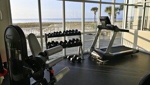 A gym with a treadmill, dumbbells, and weight machines. - Summerwind West #202 Oceanfront Condo - Free Beach Chairs & Umbrella. (Navarre Beach)
