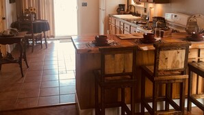 Una cocina amplia con armarios de madera, una isla central y un comedor con mesa y sillas.