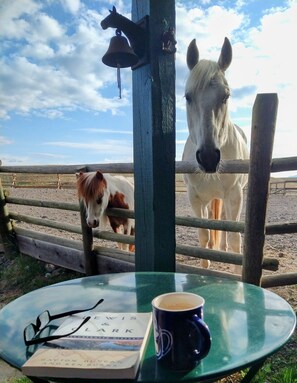 A table with a book, a mug, and a pair of glasses.