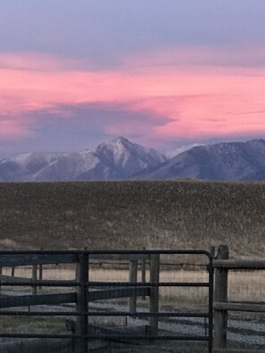 A mountainous landscape with a pink sky at the horizon.