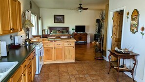 A spacious kitchen with wooden cabinets, a central island, and a dining area with a table and chairs.