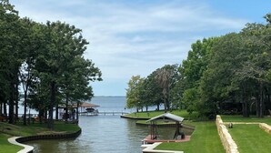 A lakeside park with a gazebo, lounge chairs, and a walking path.