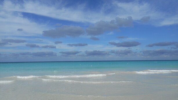 A beach with clear turquoise water and a sandy shore. - Chippewa Village Pool Apt  (Negril)