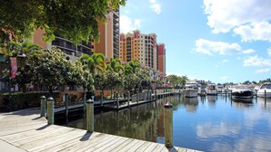 Un hôtel situé au bord de l’eau, doté d’un quai en bois, d’un canal et de bateaux.