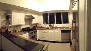 A modern kitchen with white cabinets, a stove, and a sink.