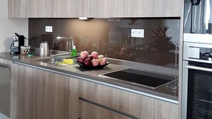 Une cuisine moderne avec des meubles en bois, un évier en acier inoxydable et un four encastré.