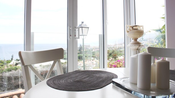 A table with a placemat, candles, and a salt shaker.