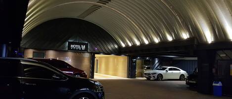 A hotel parking garage with cars parked inside.