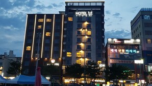 Un hotel de varios pisos, ventanas iluminadas y un letrero destacado.