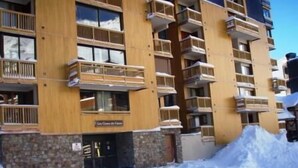 A multi-story hotel with balconies and a stone facade.