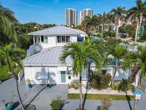 A two-story house with a grey roof, surrounded by palm trees and a parking area. - one bedroom furnished apartment by beach (West Palm Beach)