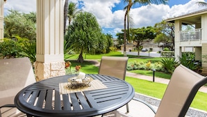 Un patio con una mesa redonda, sillas y un adorno decorativo.